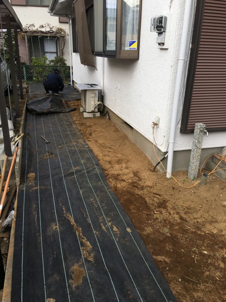 家の脇に防草シートを敷いているところ